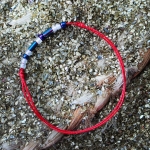 Гривна против уроки с червен конец и сини мъниста